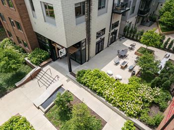 A courtyard surrounded by buildings with a bench and a table.
